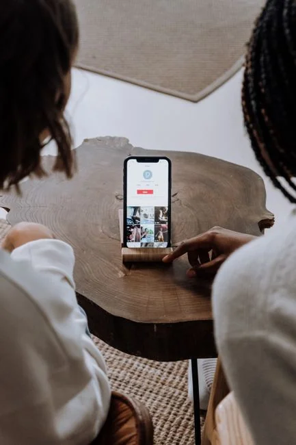 Hands gesturing during a video call on a laptop screen, with two people taking part in a virtual meeting.